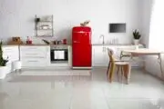 A red fridge in a white kitchen uses the unexpected red theory design strategy