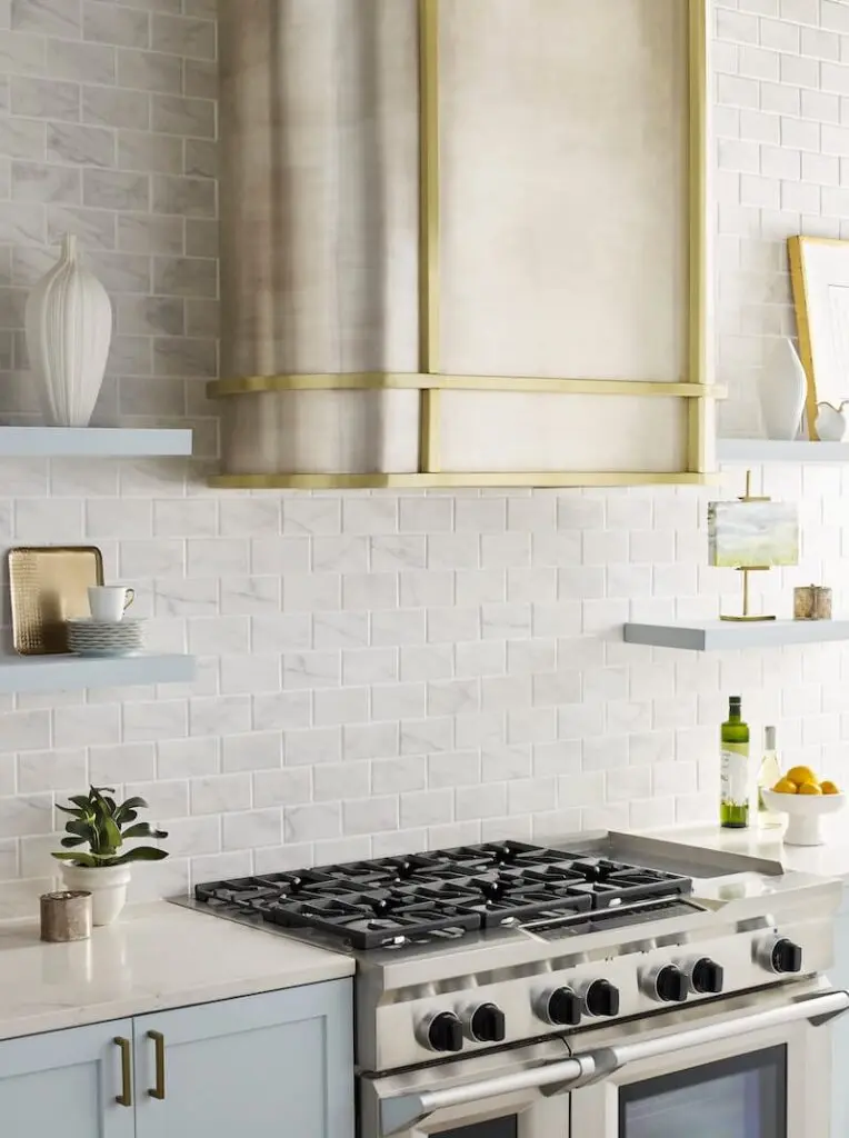 Metallic range hood with accents over a gas stove